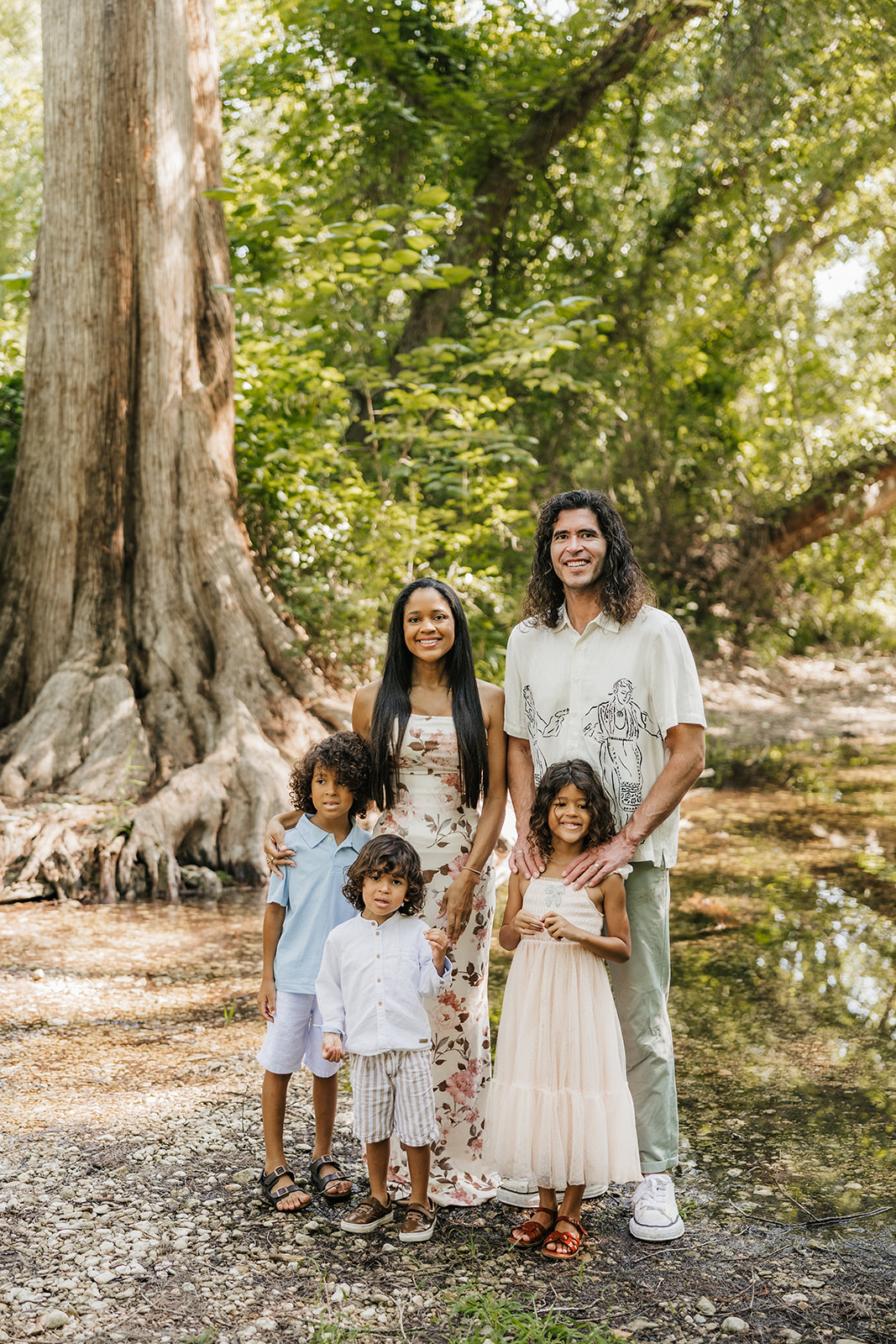 All five Santucci family members standing beside a creek